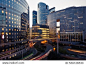 Night architecture. Skyscrapers with glass facade. Modern buildings in Paris business district. Evening dynamic traffic on a street. Business, economy and finances concept.  Copy space for text. Toned