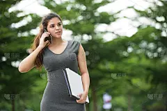 自信的女人拿着文件打电话