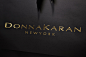 Nothing speaks to sophistication like black minimal packaging. Donna Karan’s luxury retail packaging does just that with black beater-dyed paper for dark richness and an embossed, metallic gold hot stamp logo.