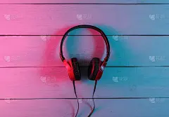 木质背景的有线耳机。霓虹蓝红渐变光。复古浪潮，80年代流行文化。俯视图