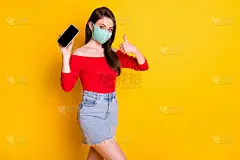 照片女孩医用口罩展示智能手机竖起大拇指提示推荐新型冠状病毒检疫装置穿红色上衣短迷你型牛仔牛仔裤裙子孤