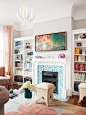This bright white living room created by Coddington Design gets a colorful focal point from 1970s-inspired artwork filled with aqua, orange, purples and pinks.