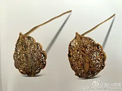 #藏品赏析# 早上好，昨天欣赏了美丽的金冠，今天来看看这对凤凰纹金簪。金簪镂空设计，钗头呈桃形，边缘如九片相连的花瓣，以五层金薄片压膜而成。正面使用垒丝、盘丝工艺，以凤凰为主纹饰，飞舞于云间。背面用金丝盘成缠枝卷草纹。纹饰精美繁复，凤凰栩栩如生，显示了当时工匠的精湛技艺。