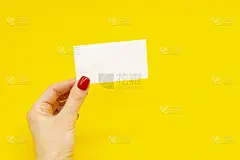 女人的手与时尚的红色美甲拿着名片在黄色的背景。夏季春季美甲设计。