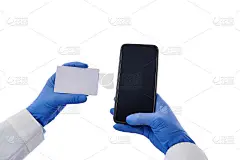 特写医生的手在保护医疗口罩拿着塑料空白名片和智能手机孤立在白色背景与拷贝空间。健康保险的概念
