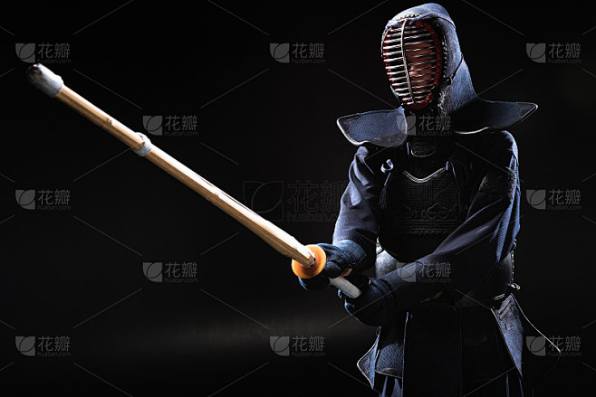 剑道战士在盔甲与竹剑在黑色练习