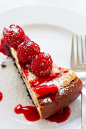 Easy raspberry cheesecake recipe yields a slice of raspberry cheesecake on a plate with raspberry sauce topping.