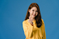 Young asia lady with positive expression, shows hands gesture in heart shape, dressed in casual clothing and looking at camera isolated on blue background. happy adorable glad woman rejoices success. Free Photo