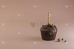 巧克力松饼，粉红色背景上的金色蜡烛。节日的概念。生日贺卡快乐，结婚纪念日快乐。极简主义