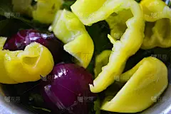 一片片青椒、青欧芹和红洋葱放在银色的不锈钢垫上。