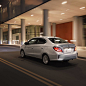 Back view of a silver 2024 Mitsubishi Mirage G4 Sedan driving in the city