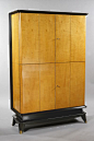 Art Deco Cabinet Maurice Jallot (1900-1971) France, ca. 1940 Sycamore and stained fruitwood. Four-door cabinet with one wide shelf in each section and a pull-out tablet at the midpoint, hidden by the closed doors. Cabinet raised on a stained plinth with b