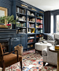 Navy walls with built-in bookshelves and orange boho rug | Meredith Heron