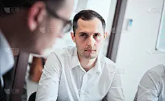 一群商务人士在一个现代化的办公室里，工作的商人策划创意产生和商业计划。商人们正坐在计划会议的桌旁。经