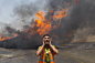 Palestinian firefighters try to extinguish fire at UN storehouse after an Israeli military strike in an area west of Gaza City on July 12. (MAHMUD HAMS/AFP/Getty Images)