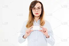 美丽的女商人与名片孤立在白色的背景。年轻女孩与卡片摆姿势。本空间