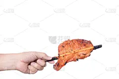 手拿木炭烤鸡腿或烤鸡腿肉串，一种传统的泰国街头食品