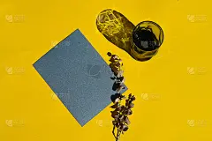 黄色的桌子上放着有阴影的纸卡和玻璃。