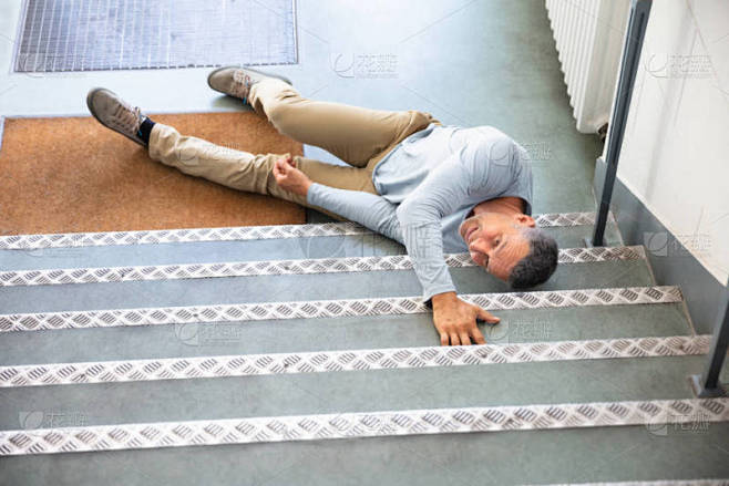 一个成熟的人在滑倒和摔倒事故后躺在楼梯上