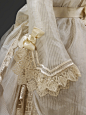#服装# 婚服，1872~1874，白色薄纱与丝缎相间的细条纹布料，装饰奶油色刺绣蕾丝花边与缎带花结，虽然整体看来层层叠叠很复杂，但因为布料半透明的质感，所以感觉还是挺轻盈的~ ​​​​