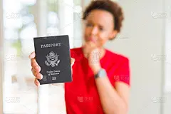 年轻的非洲裔美国妇女拿着美国护照严肃地面对思考问题，很困惑的想法