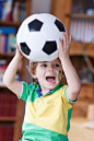 Little boy with football watching soccer