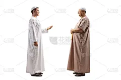 两名身着民族服装的男子正在交谈的全身侧脸照片