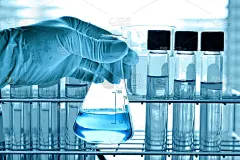 有实验室玻璃器皿背景的科学家手上的烧瓶