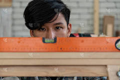 木匠在车间加工木制品以生产建筑材料或木制家具.这位年轻的亚洲木匠用专业的工具做手工.DIY制造商和木