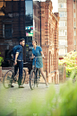 一对年轻夫妇坐在城市对面的自行车上
