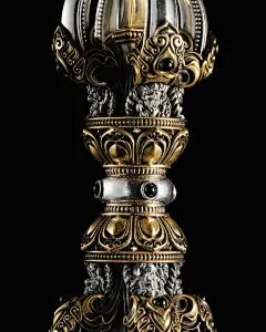 This may contain: an ornate gold and silver vase with two lions on it's sides, against a black background