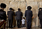 耶路撒冷。犹太男孩和他的父亲在圣殿哭墙前面壁祈祷。