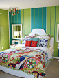 俏皮是这间房给人的第一感觉，简单的白色床柜，绿色和蓝色条纹的墙纸，制造了一个很简单的背景，但是主人用了充满活力的床上四件套去点缀了。