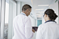 Doctors consulting, reviewing digital x-ray on digital tablet in clinic corridor by Hero Images on 500px