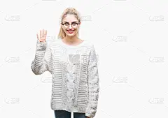 年轻美丽的金发女人戴眼镜在孤立的背景显示和指向第四个手指，而微笑自信和快乐。