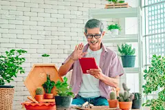年长的亚洲人正在用笔记本电脑视频呼叫家人在家里的花园。
