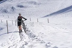 一位善良的女士在春雪中推着她的电动自行车