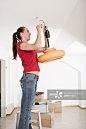 Woman fixing lamp in new home