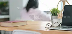近距离观察舒适的工作场所，开放笔记本电脑和办公用品与模糊的办公背景
