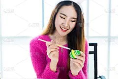 复活节节日概念，快乐亚洲年轻女子戴着兔子耳朵手绘复活节彩蛋与彩色复活节彩蛋在白色的房间背景