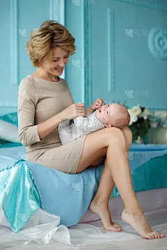 妈妈陪着宝宝玩，把他放在自己的膝盖上