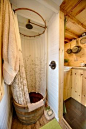 I love the hooped barrel bath / shower in the rustic bathroom from the Tiny Tack House