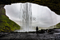 女徒步旅行者在洞穴里看着Seljalandsfoss瀑布照片摄影图片_ID:349318061-Veer图库