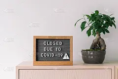 因新冠肺炎停业的店铺。冠状病毒生活方式背景，在商店前柜台张贴关闭商铺和零售店的信息标志