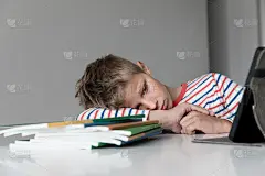 伤心的男孩厌倦了读书，做作业