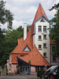 This may contain: a large building with a red roof and blue windows