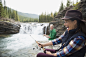 Enthusiastic senior woman fishing catching fish at waterfall by Hero Images  on 500px