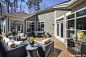 A sunny outdoor living space with matching furniture and a brick patio floor.