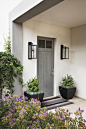 Contemporary Gray Front Door  : Architect Bill Bocken’s riff on the traditional front porch marks the entrance to this Del Mar home. Lanterns from Gibson & Gibson antique lighting flank the front door.