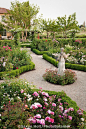 Gravel path through California flower garden with statue as focal point in formal garden room of English (Austin) roses with pink Rosa 'Lill...